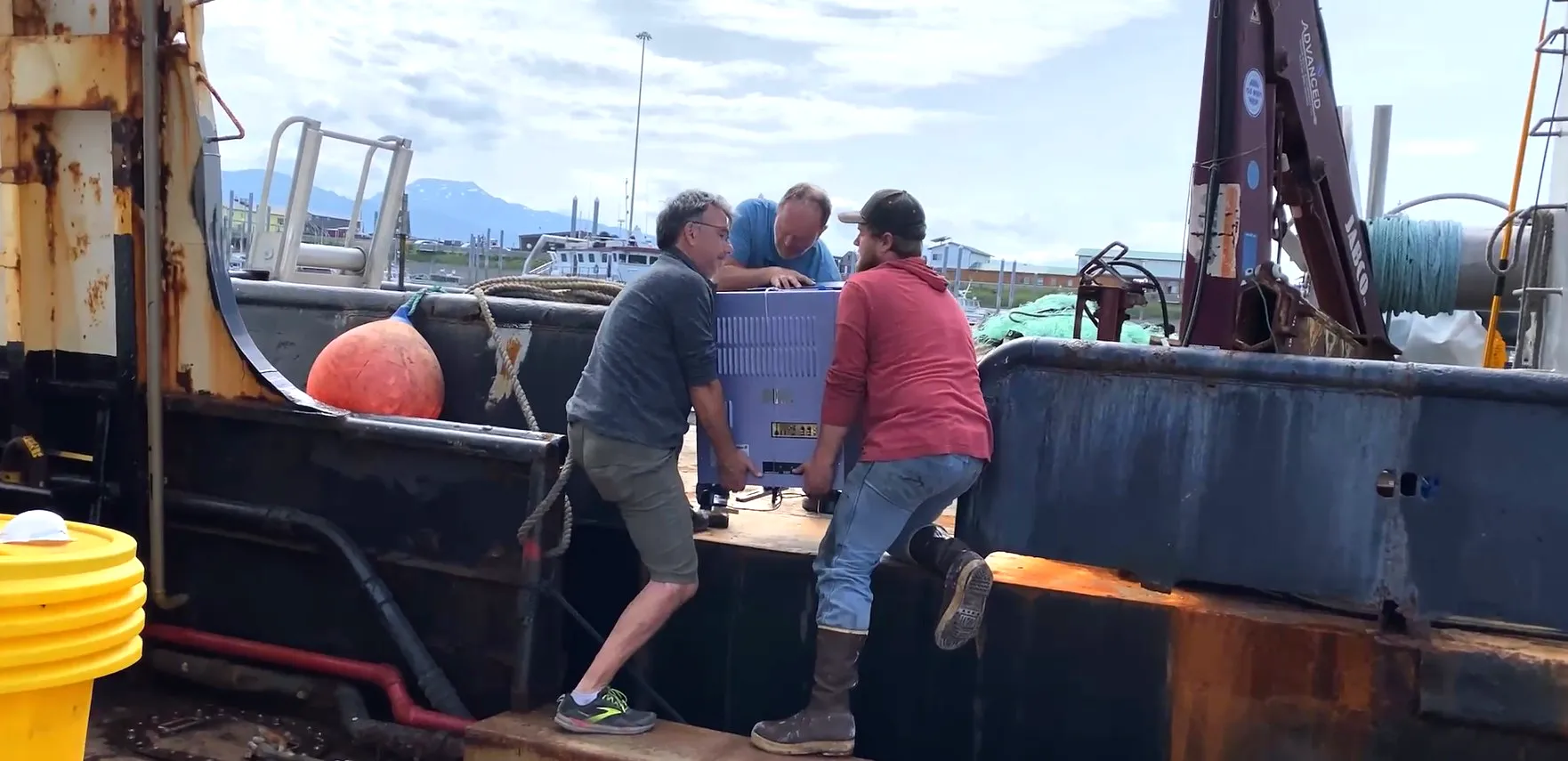 Men loading equipment on fishing vessel